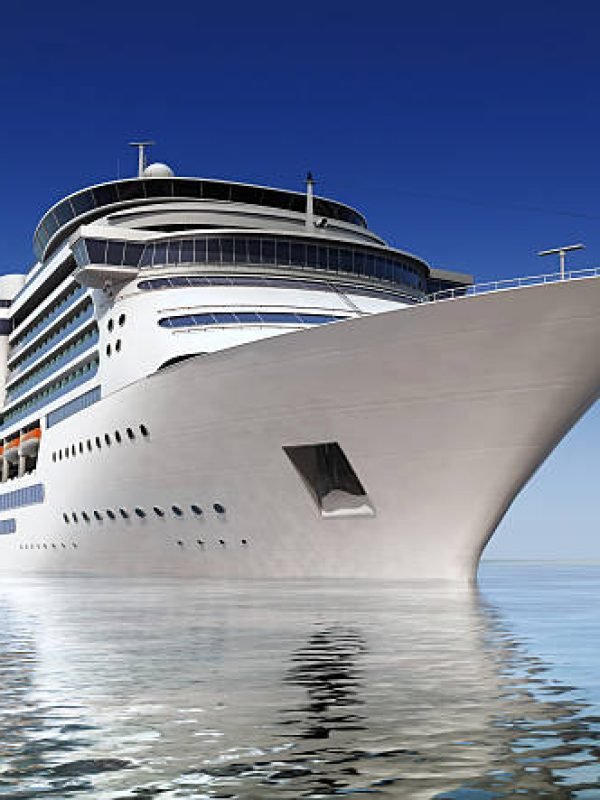 luxury white cruise ship shot at angle at water level on a clear day.